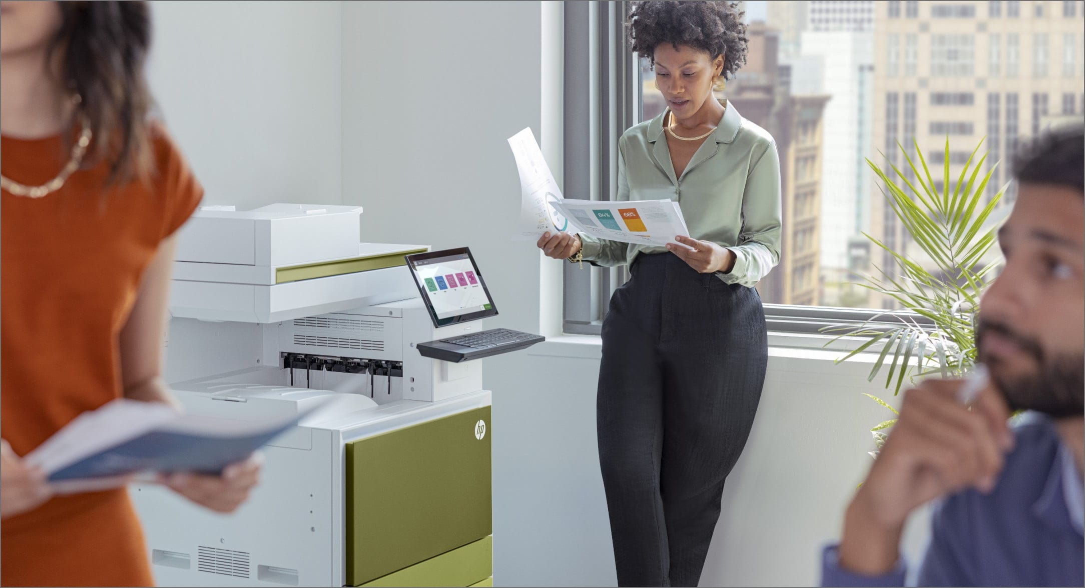 Woman standing in front of office window looking at printed documents next to HP LaserJet Managed printer