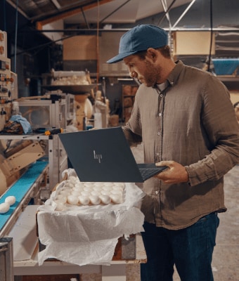 Man using HP laptop in a factory.