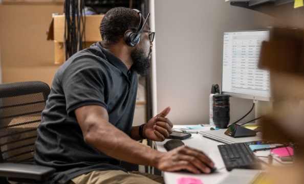 An IT man man checking some data on his HP monitor.