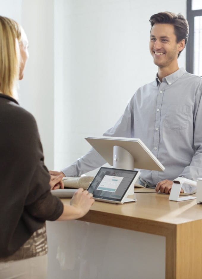 A man attending a woman using an HP Engage One Pro computer.