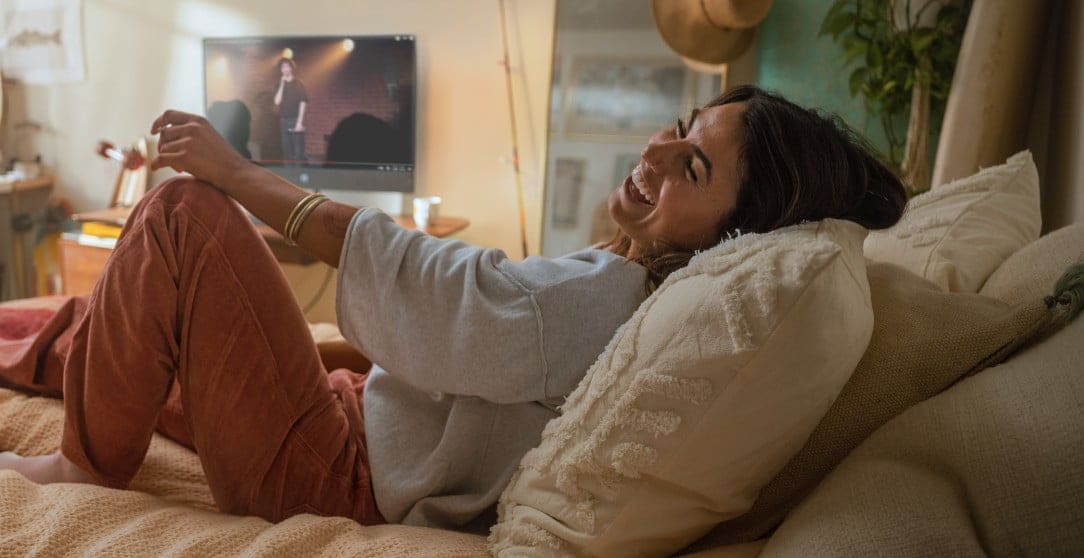 A woman having fun while watching a concert on her HP computer.