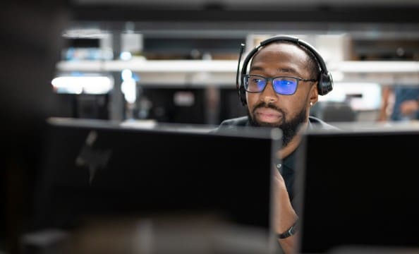 A man working on two HP monitors in his office.