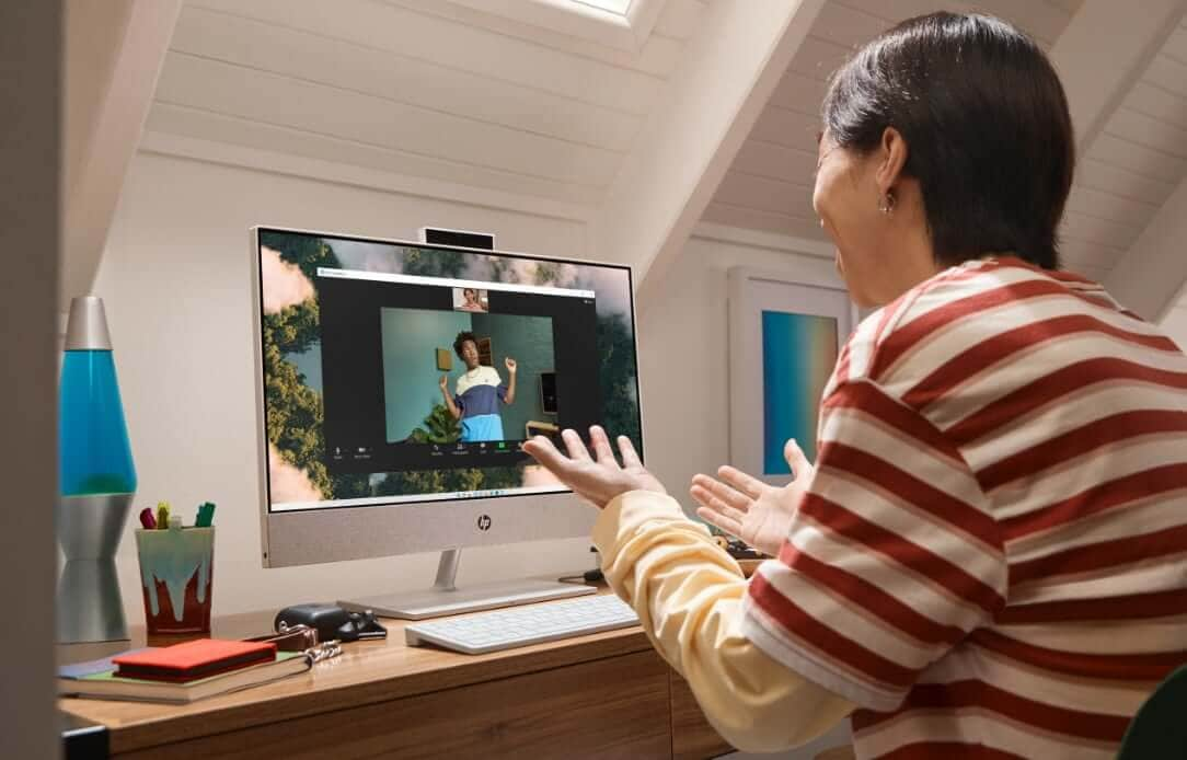 A woman having a virtual conference on her HP Pavilion All-in-One computer.