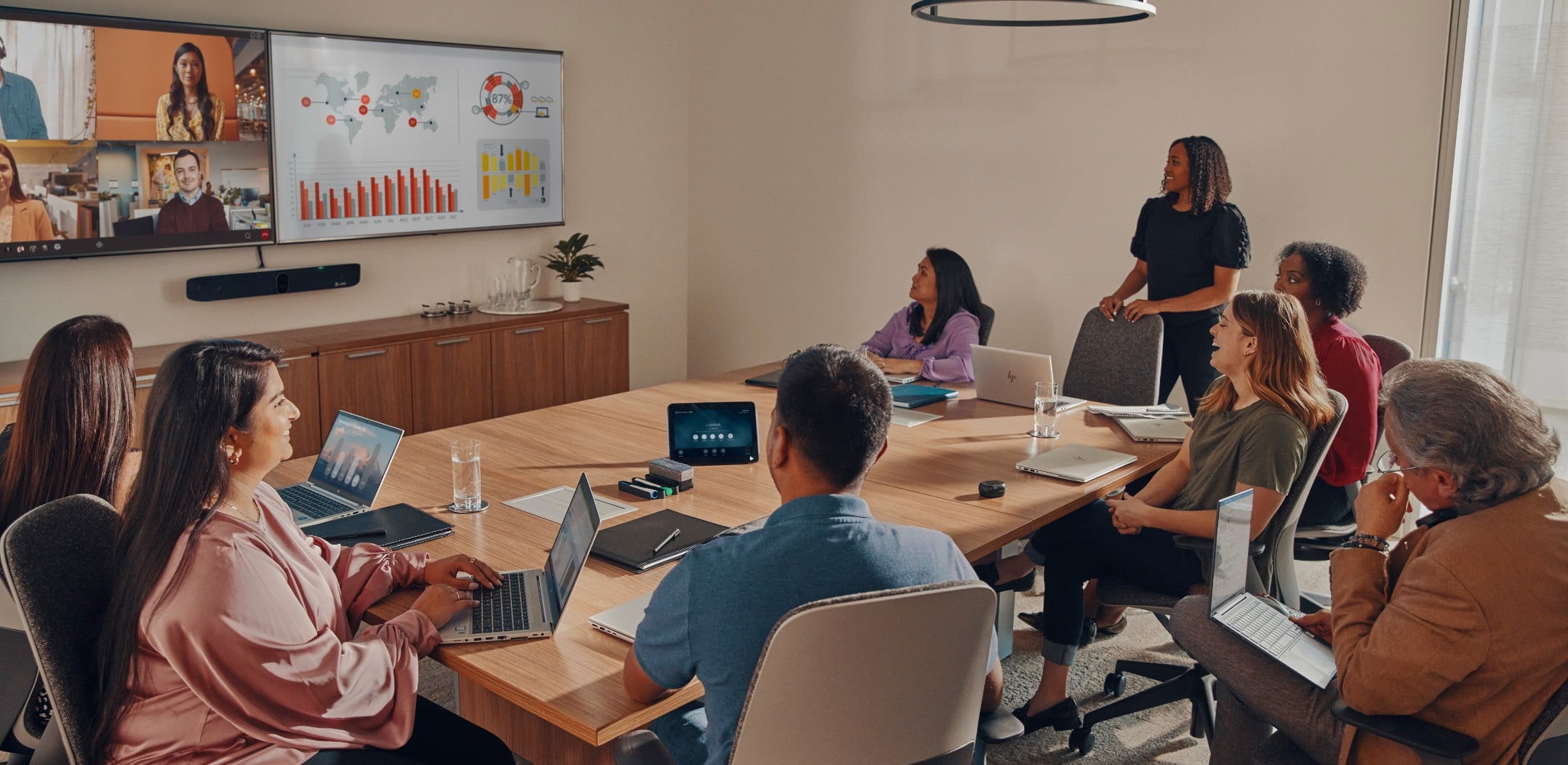 Large conference room with many people engaged in a video and content sharing call, using the Poly Studio X70 all-in-one video bar 