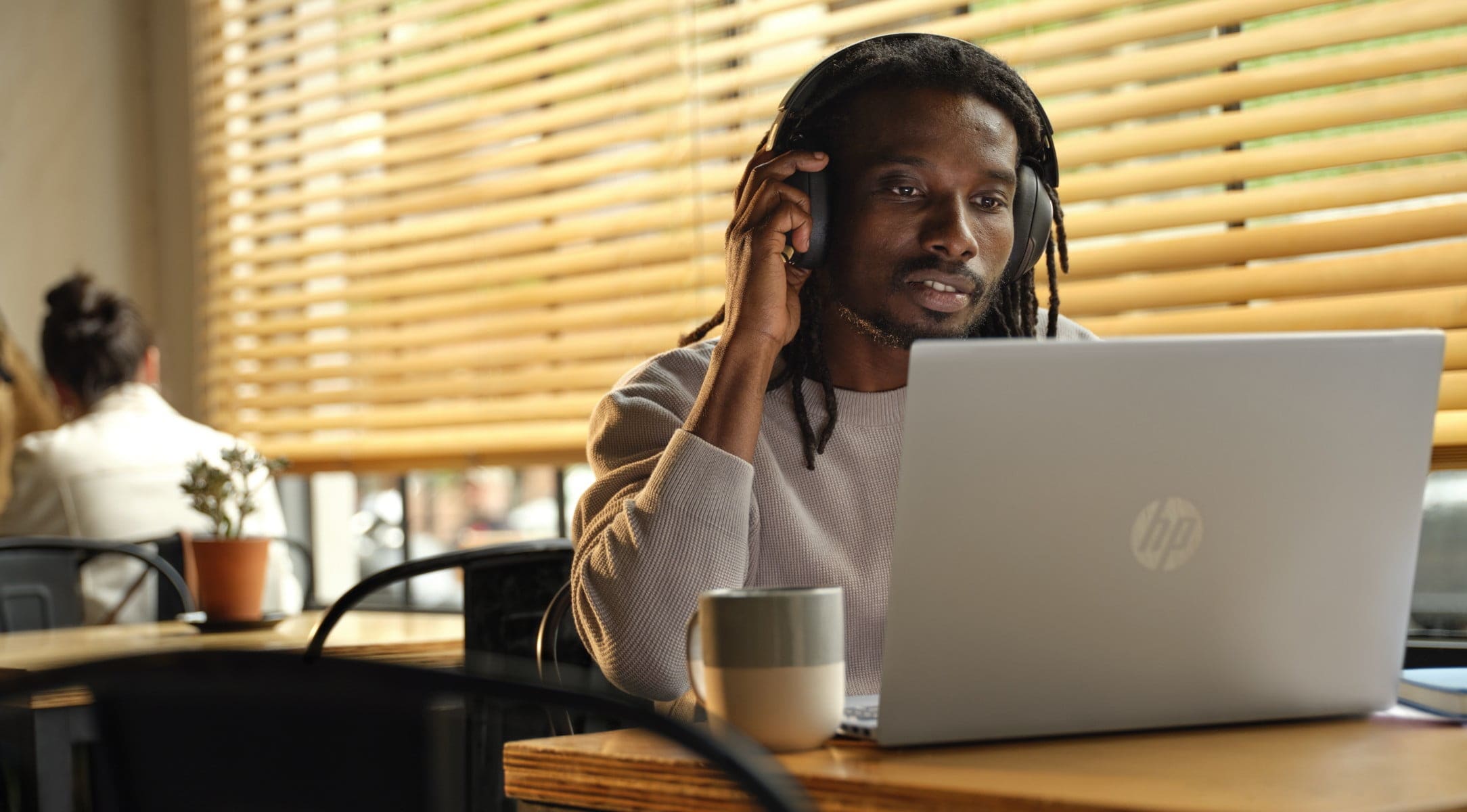 Man sitting in van holding and touching laptop as a tablet