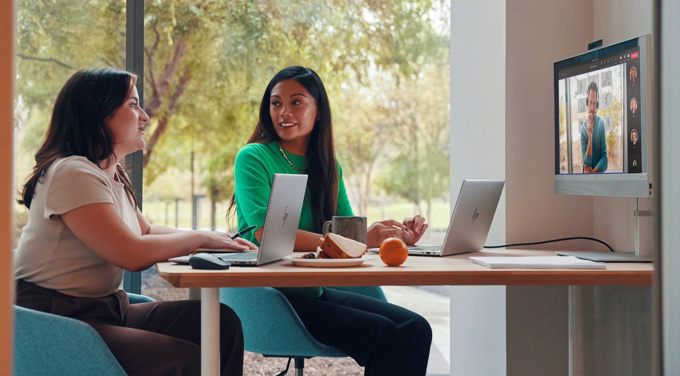 Business women using HP devices in conference room