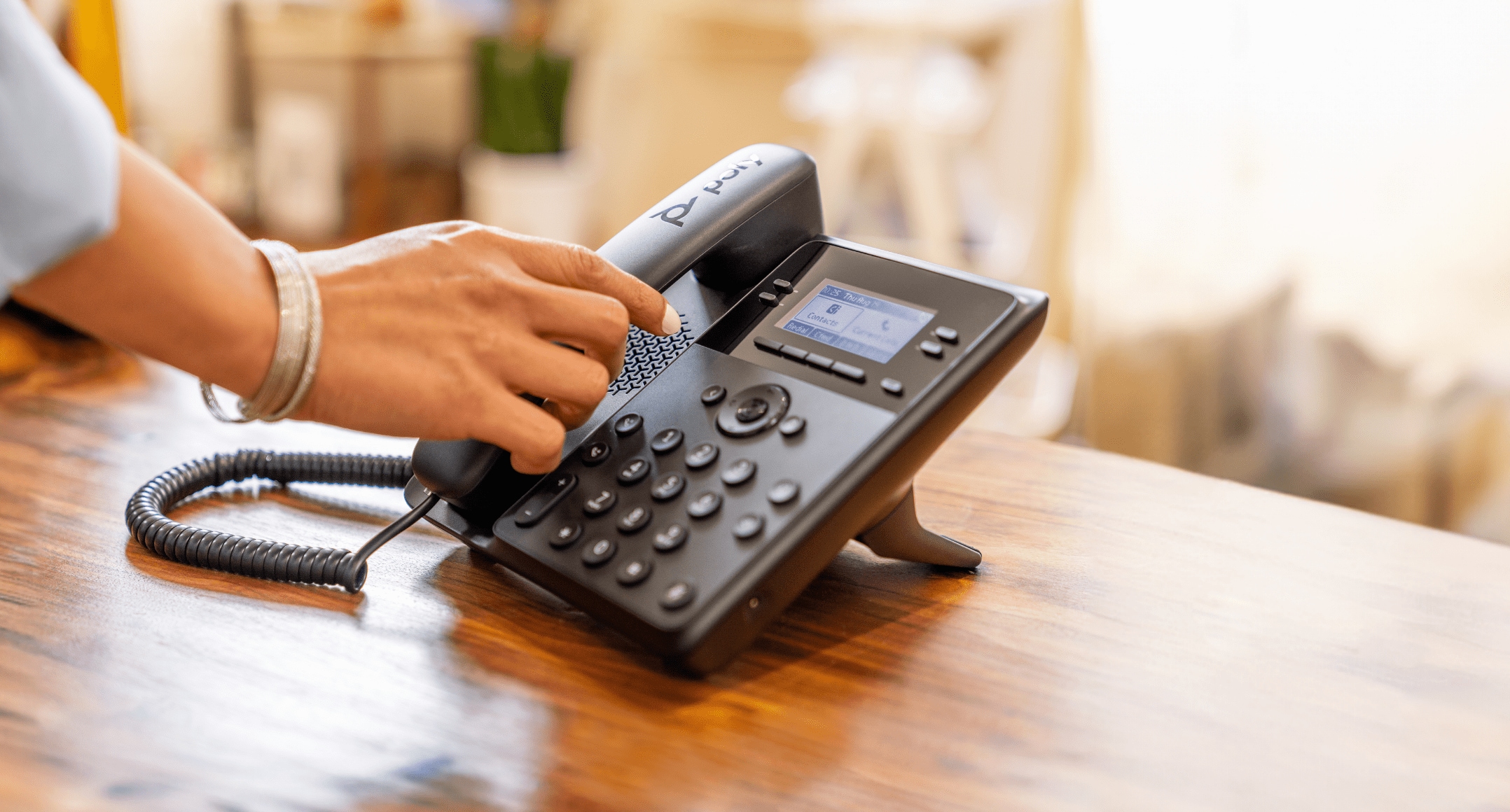 Front view of Poly Edge B10-B20 IP desk phone with handset, showing onscreen menu