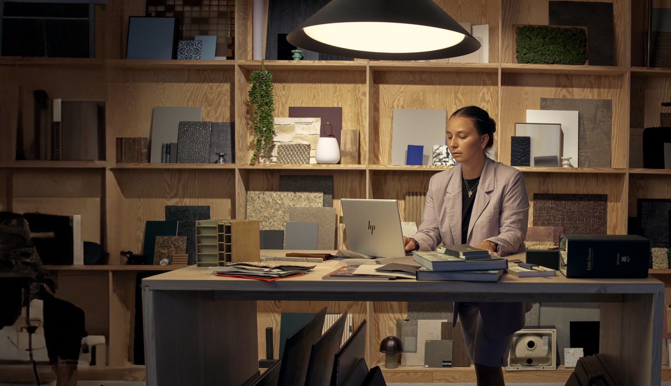 Woman working at a desk with HP EliteBook laptop.