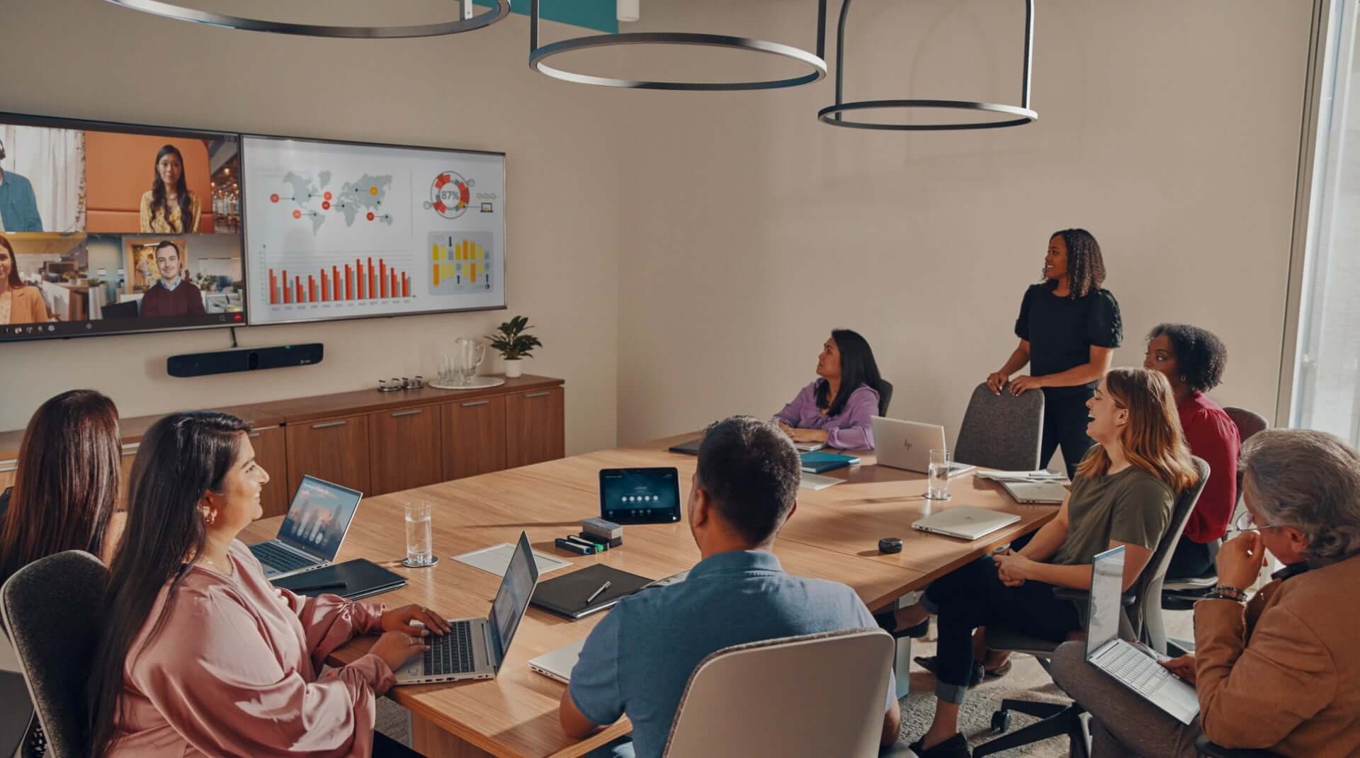 Large conference room with people engaged in a video call using Poly Studio X70 all-in-one video bar