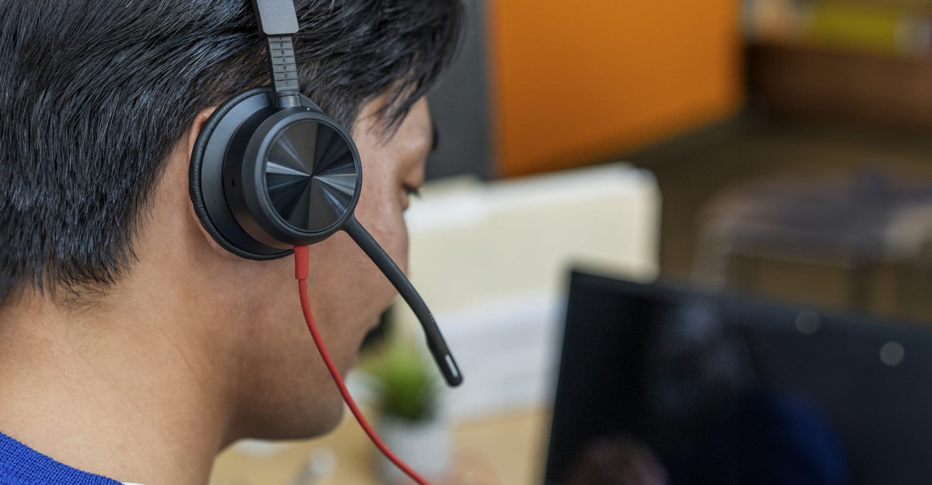 Close-up of man wearing Poly Blackwire 8225 USB headset