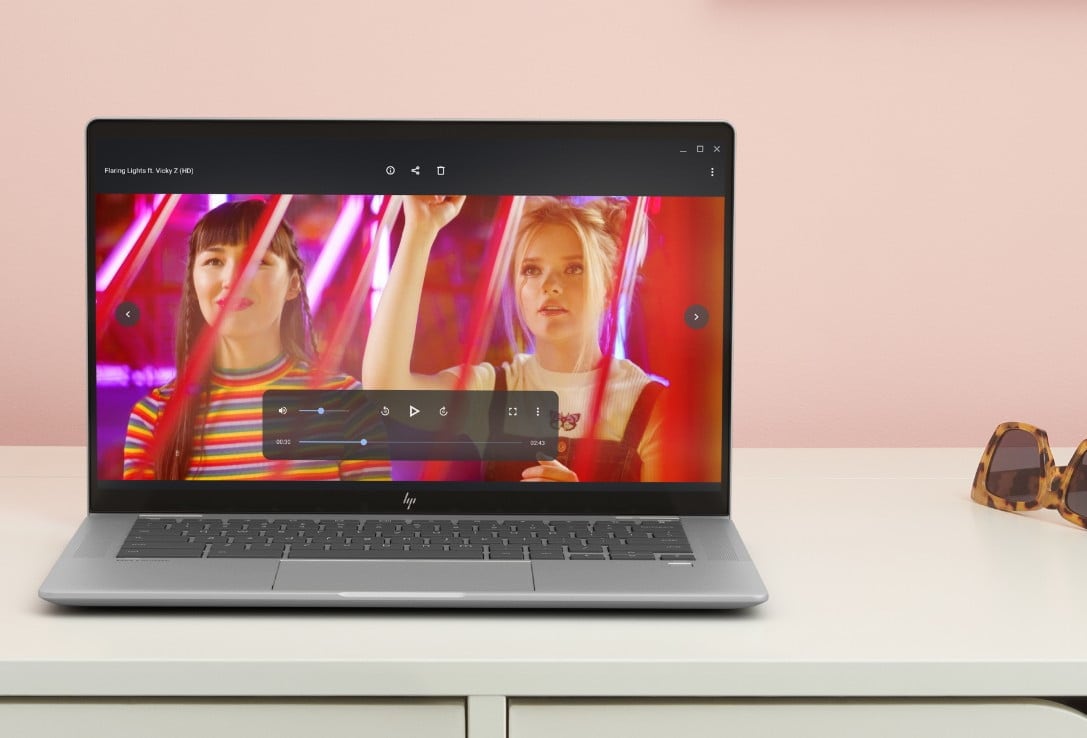 An HP Chromebook on top of a white desk showing a video on the screen.