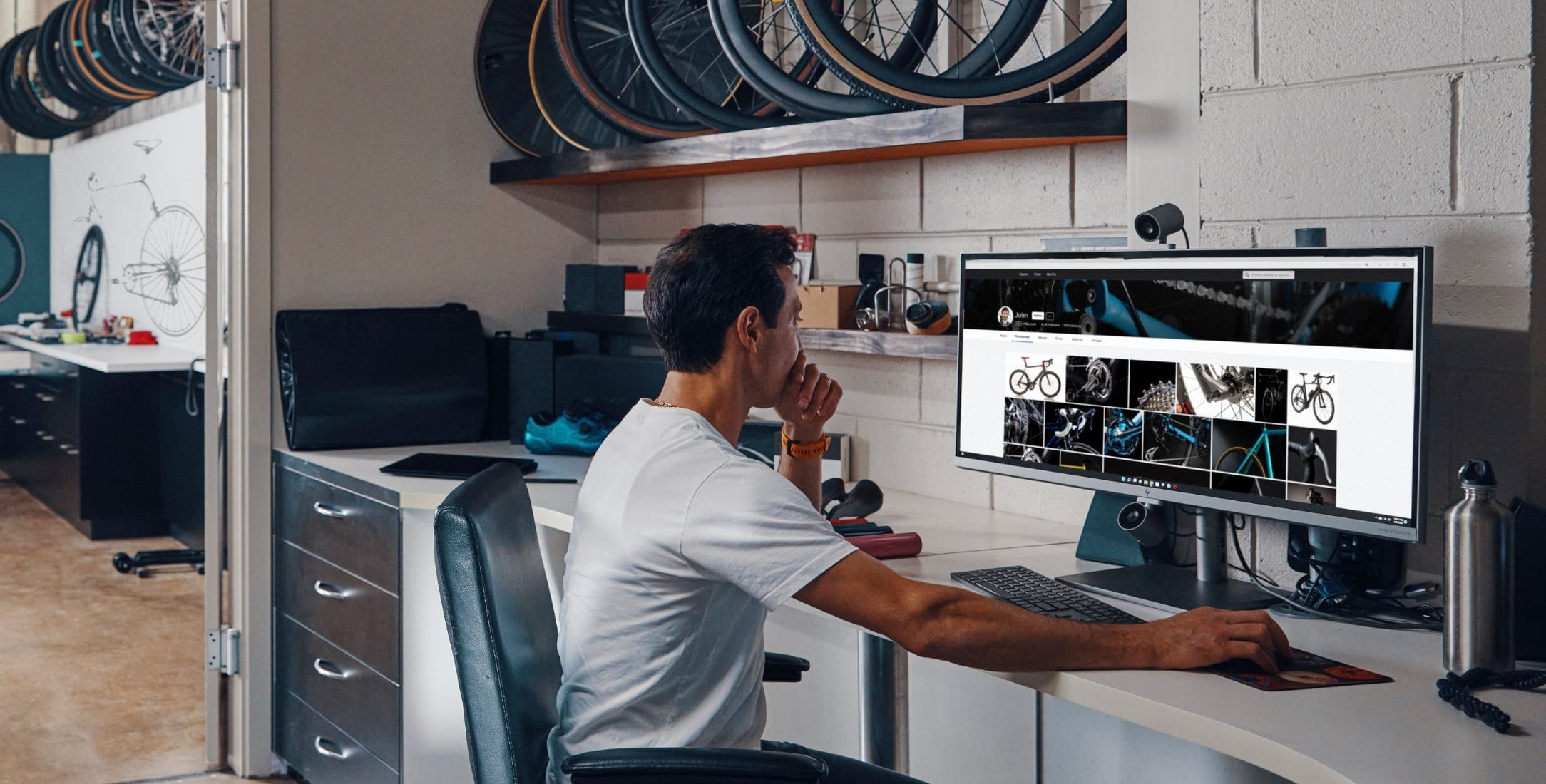 A man working on an HP All-in-One pc on top of a desk.