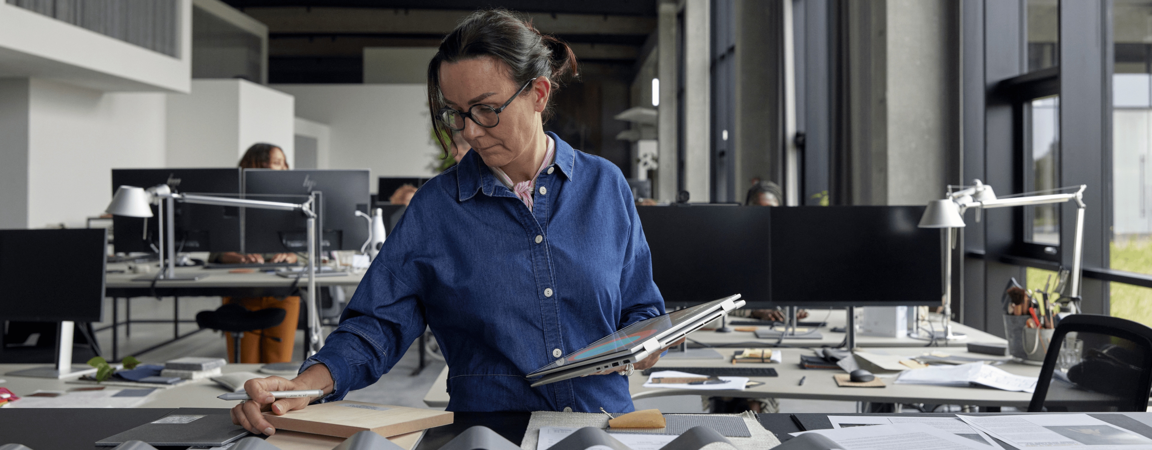 Woman taking some notes on her HP EliteBook on tablet mode while standing.