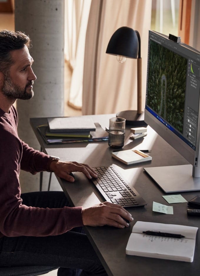 A man working on an HP EliteOne 800 All-in-One pc.