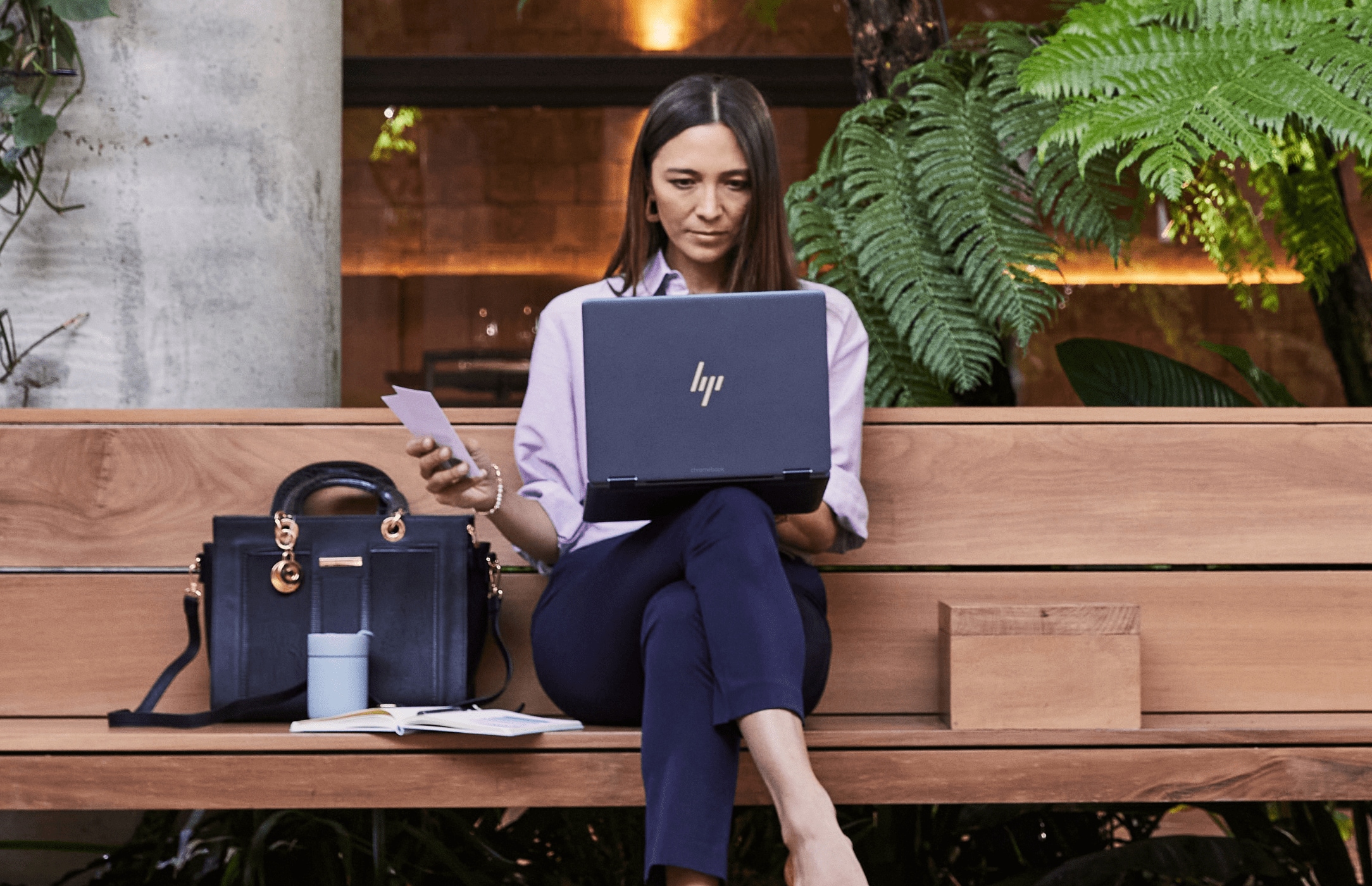 Woman sitting on bench with an HP laptop