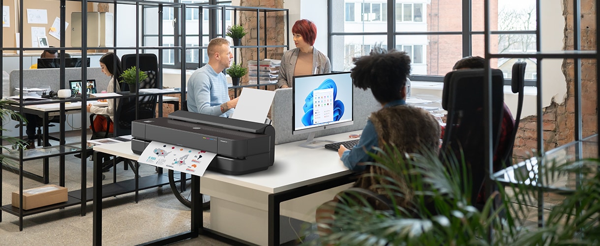 People in an office next to an HP DesignJet plotter