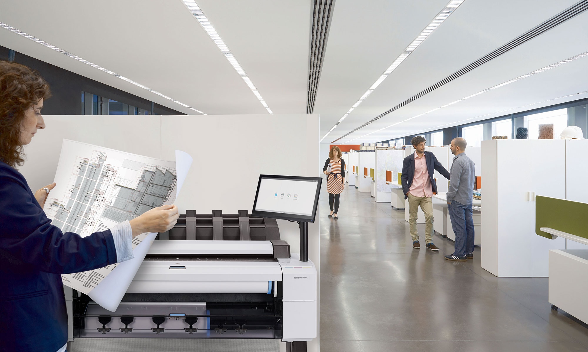 Person checking a printed media in front of the HP DesignJet T2600 multifunction plotter in an office