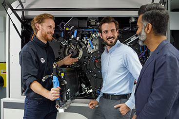 3 men performing support on a digital label press.