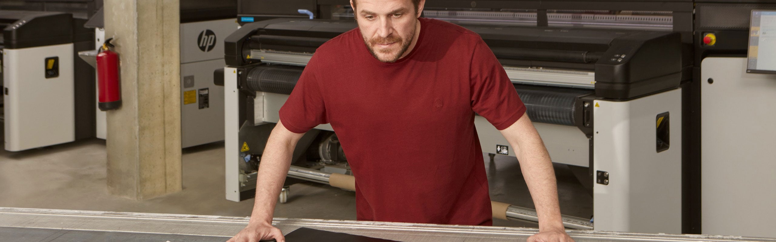 Man standing at table inspecting large color print