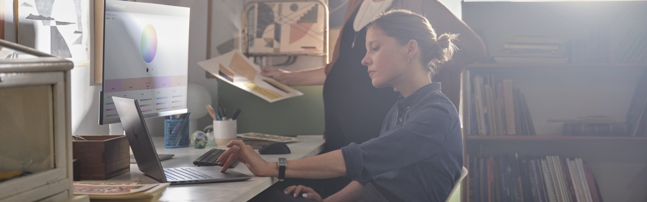 A woman having a virtual conference on her HP Envy laptop in her home office.