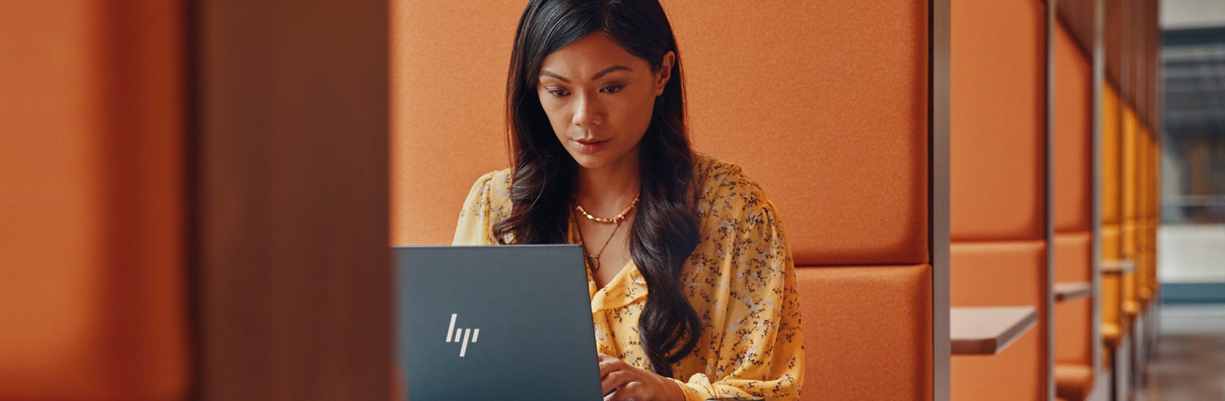 Woman in workspace using an HP Dragonfly laptop