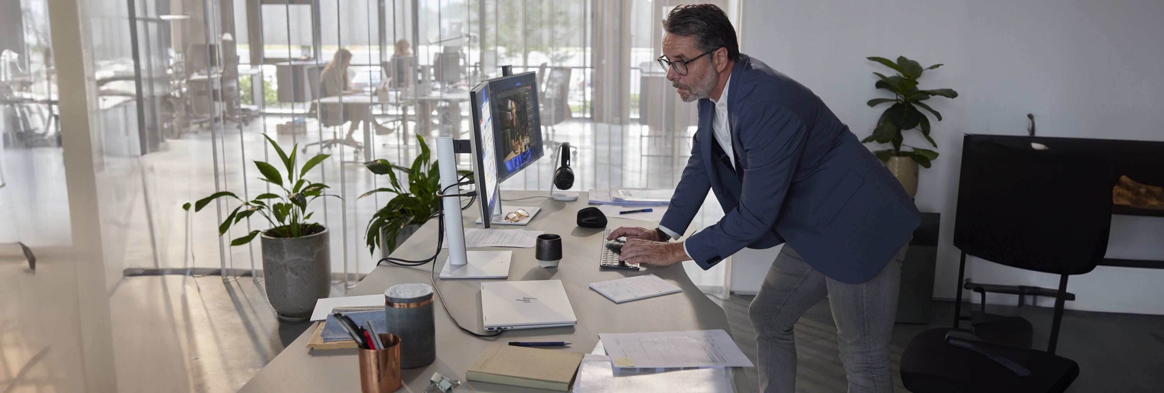 Man standing at desk, working on an HP laptop