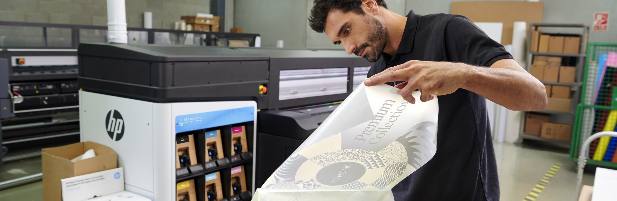 Person checking printed media next to an HP Latex printer