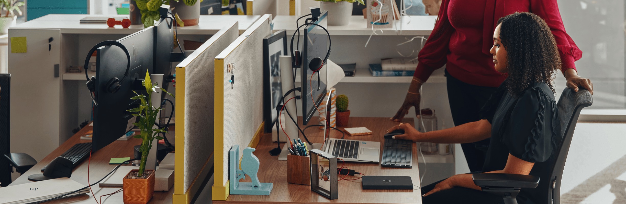 Workers helping at desktop workstation