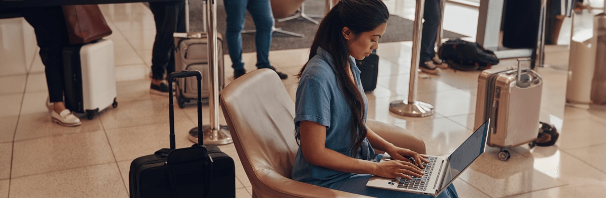 A woman checking some data on her HP laptop while she is waiting for a flight.