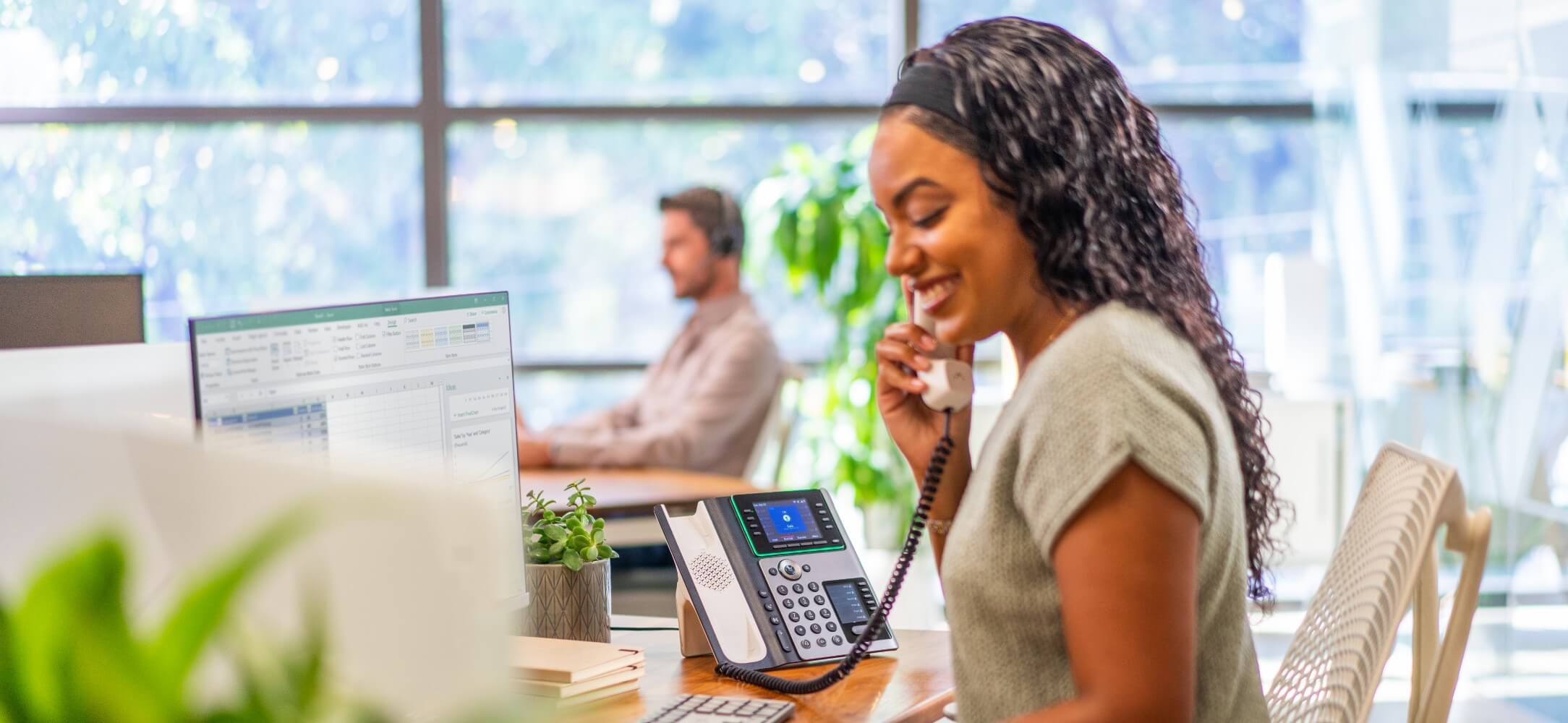 Woman at work using a Poly deskphone