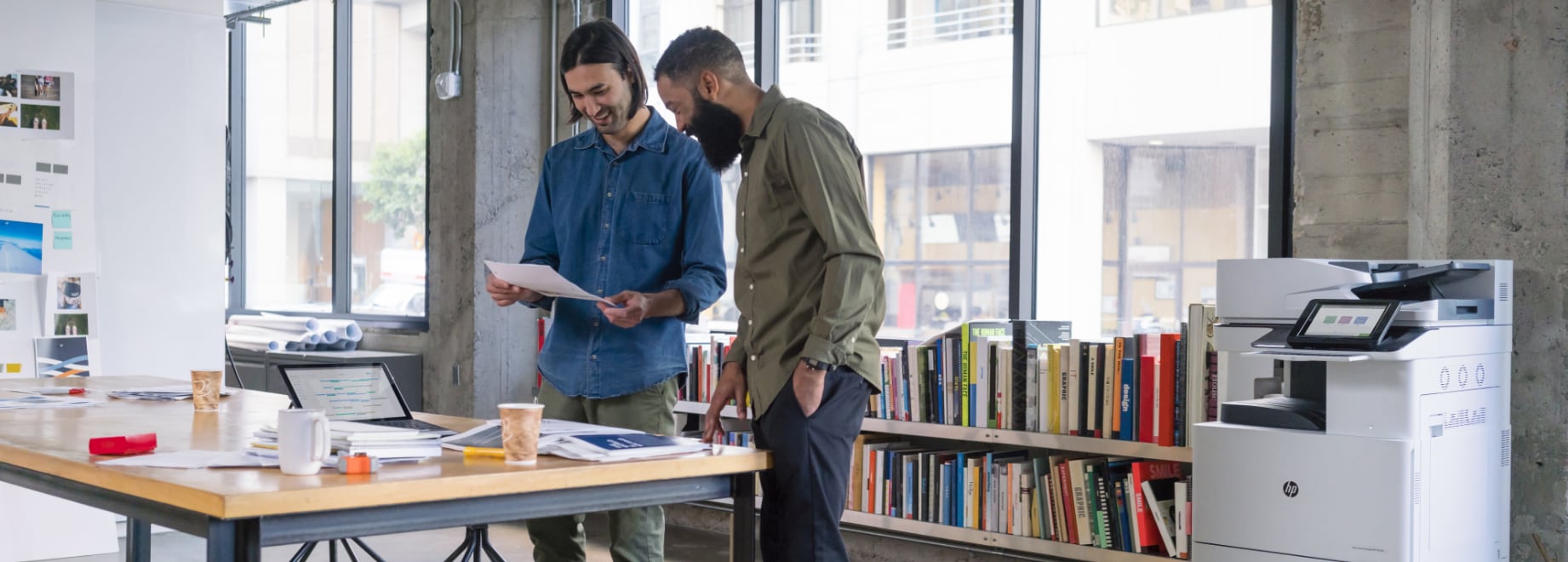 Two men in office looking at printed document with LaserJet Pro behind them