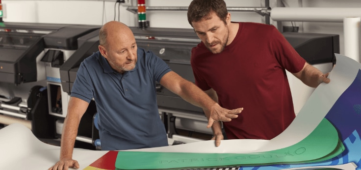 Two men looking at bright large format poster