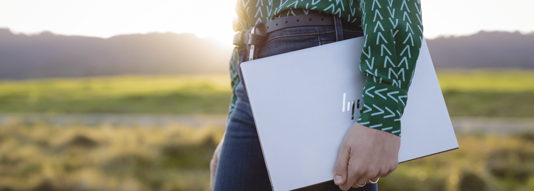 Woman holding laptop in field